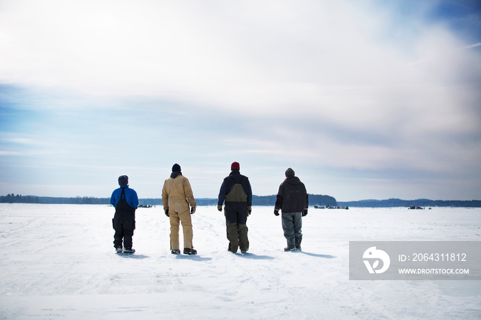 Men standing on frozen lake