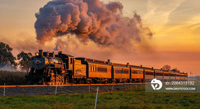 一列古董蒸汽客运列车在日出时驶近，满载蒸汽和烟雾