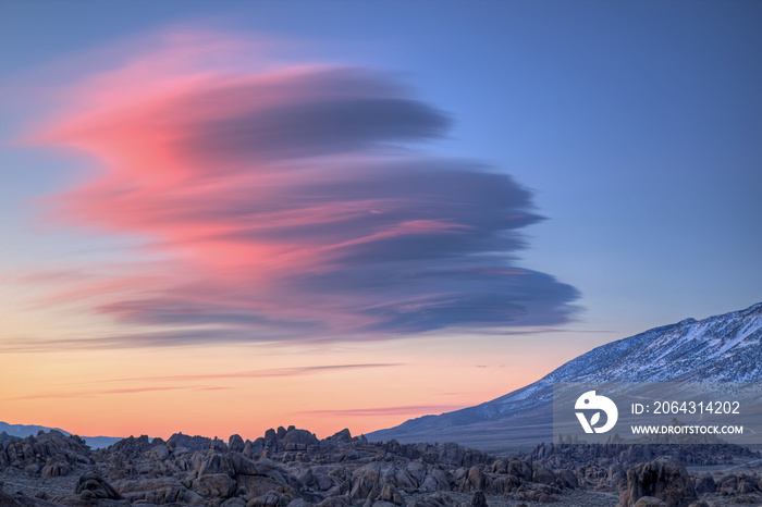 Lenticular clouds pass over the Eastern Sierra Nevada Mountains and Alabama Hills at dawn, Californi