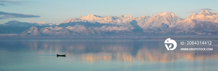 Beautiful scenic landscape  of Shkodra lake, mountains reflection and a little fishing boat