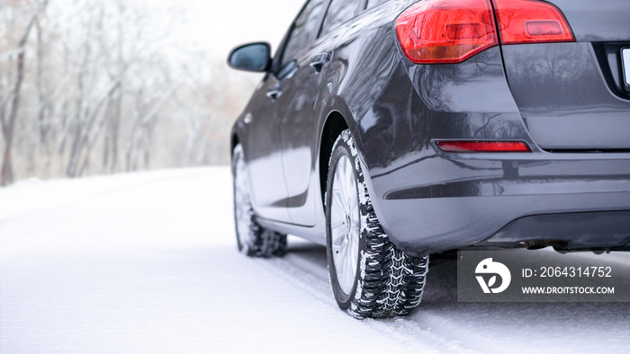 冬季道路上的汽车。雪地道路上冬季汽车轮胎的特写图像。安全驾驶理念。