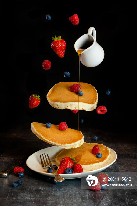 floating pancake stack with syrup and strawberries, blueberries, and raspberries