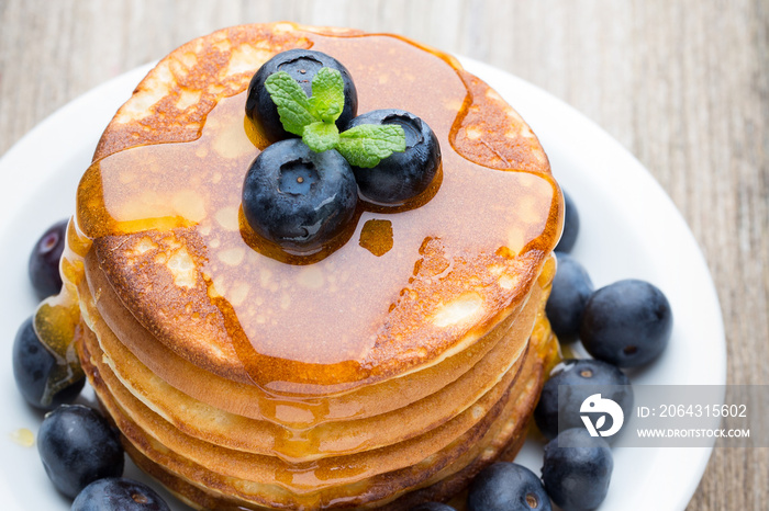 Stack of pancakes with blueberry and fresh berry.