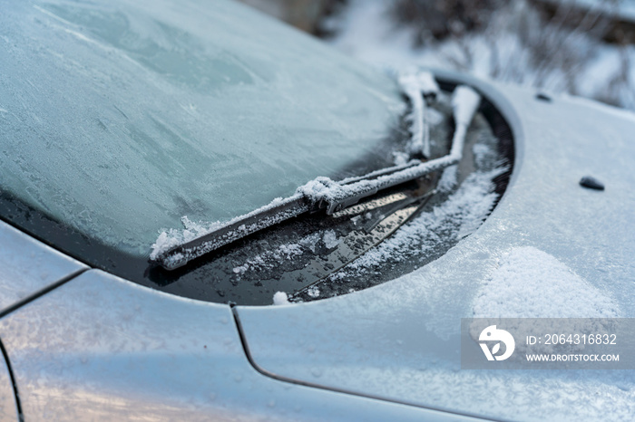 Car covered with ice and icicles after freezing rain. Ice covered car window close up. Bad winter we