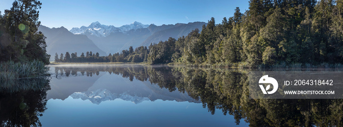 Lake Matheson New Zealand South Island. Panorama. Reflection of Fox Glacier. Snow capped moutains. S