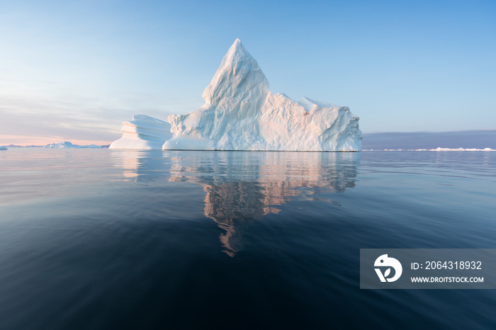 Photogenic and intricate iceberg under an interesting and blue sky during sunset. Effect of global w