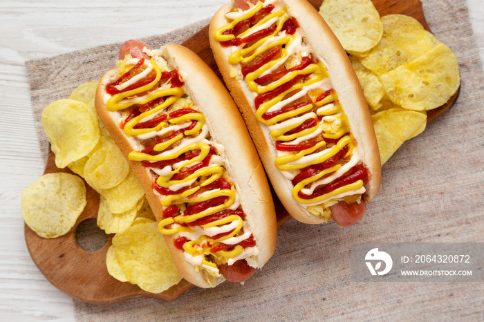 Homemade colombian hot dogs with pineapple sauce, yellow mustard and mayo ketchup on a rustic wooden