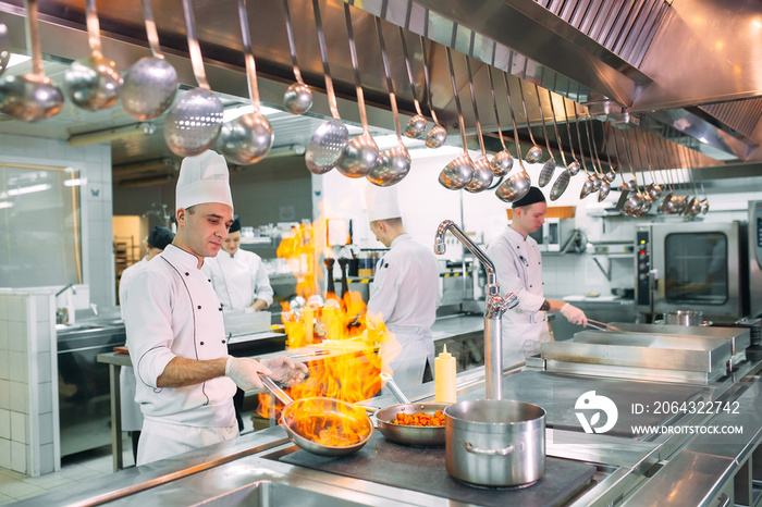 现代厨房。厨师在餐厅或酒店厨房的炉子上准备饭菜。火