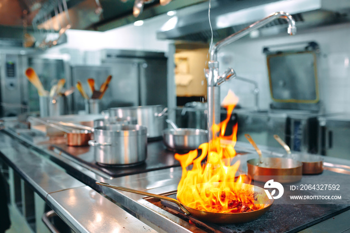 现代厨房。厨师在餐厅或酒店厨房的炉子上做饭。炉火