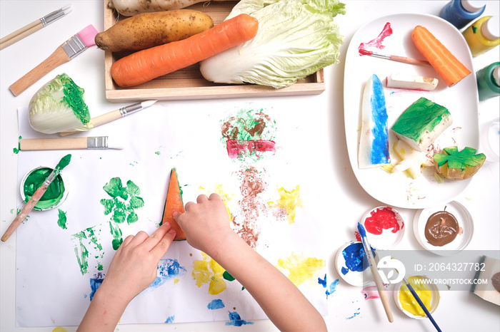幼儿手的俯视特写，孩子在家用蔬菜冲压制作艺术品，傅