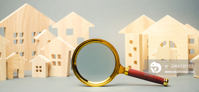 Magnifying glass and wooden houses. House searching concept. Home appraisal. Property valuation. Cho