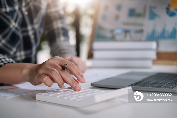 Close up hand of woman working with calculator or analyzing company financial report balance with au