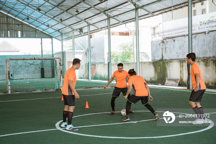 futsal player tries to prevent another player from passing