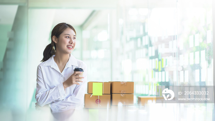 Freelance business woman smiling happy and look out the window and holding a paper coffee cup, mirro