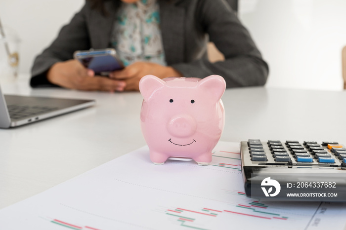 Pink piggy bank with business woman in office, saving for new business target and retirement concept