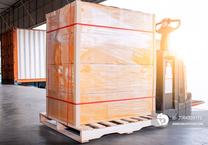 Packaging Boxes Wrapped Plastic on Pallet with Electric Forklift Pallet Jack. Distribution Warehouse