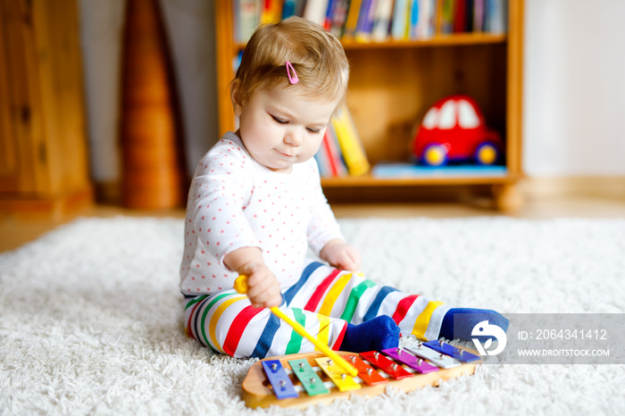 Adorable cute beautiful little baby girl playing with educational toys at home or nursery. Happy hea