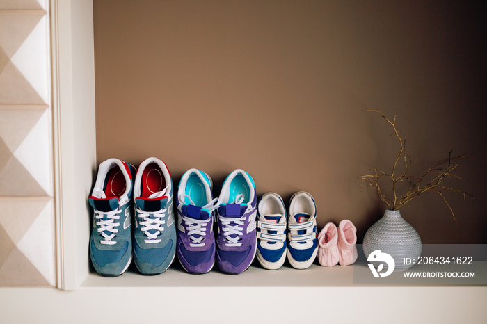 成人旁边的儿童鞋。父母鞋和托儿所。