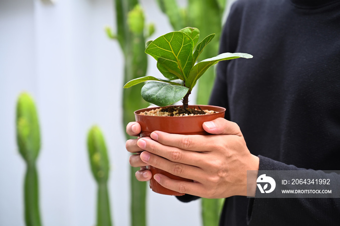 手里拿着绿色植物的年轻人。