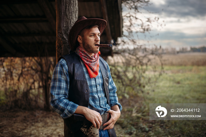 Brutal cowboy smokes a cigar, wild west culture