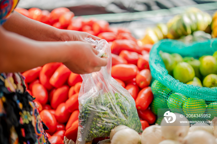 Manos de Mujer vendiendo vegetales en un mercado local.