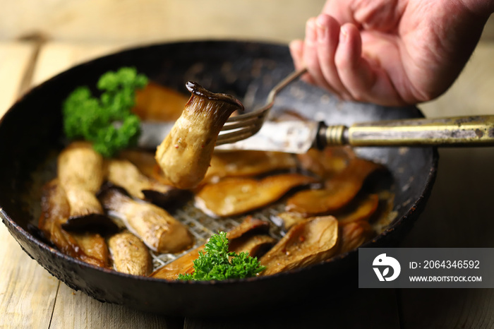 Fried eringi mushrooms in a pan. Mushroom dish.