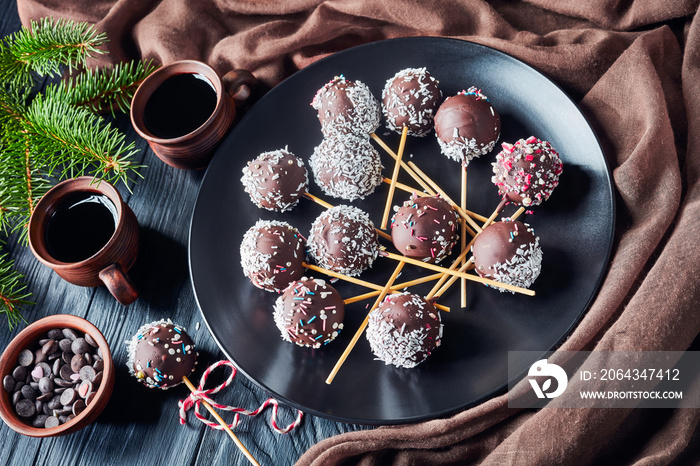 cake pops on a plate with fir limbs on a table