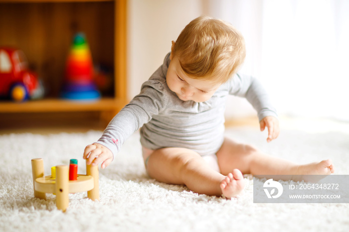 Adorable baby girl playing with educational toys . Happy healthy child having fun with colorful diff