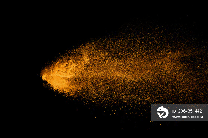 Abstract orange powder explosion isolated on black background.