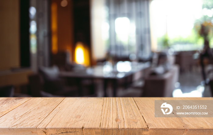 Empty wooden table in front of abstract blurred background of coffee shop . can be used for display 