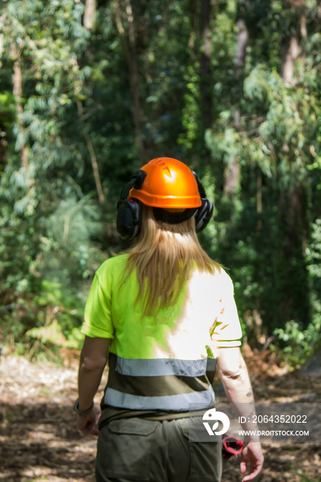 woman working in forest forest with protective helmet