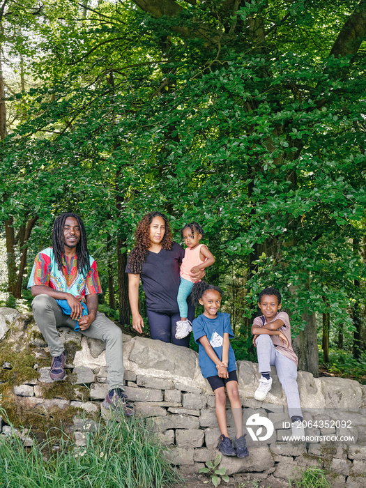 Family with children sitting on stone wall