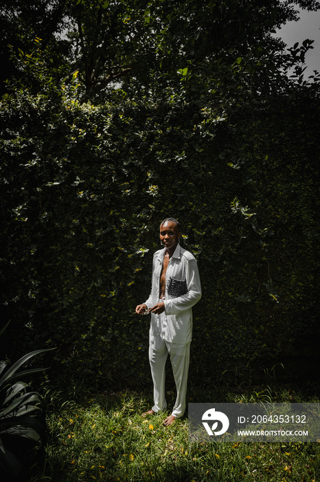 a black woman dressed fashionable posing for a portrait in a garden