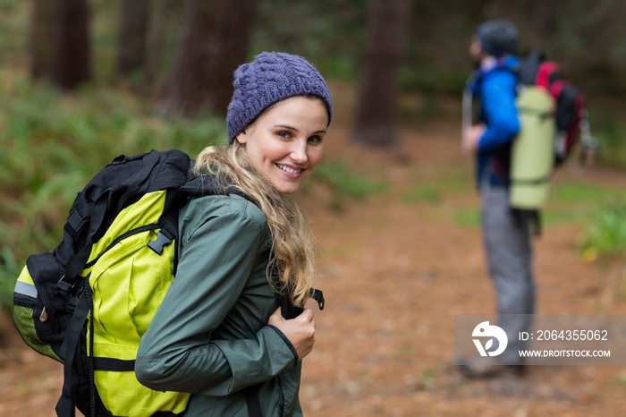 Woman looking back while hiking in forest