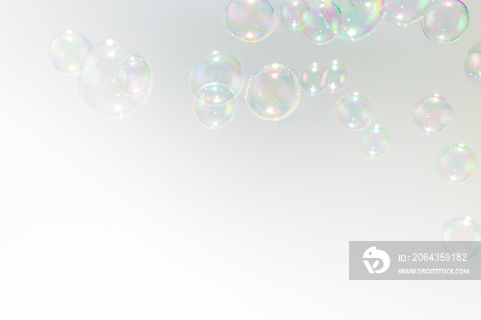 Beautiful rainbow soap bubbles float as background.