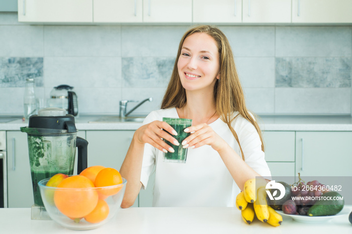 女人在家用玻璃杯喝抹茶。食品补充剂和螺旋藻。健康饮食理念。M
