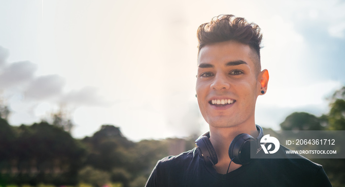 A picture with copy space of a student young man with headphones on his neck is looking at the camer