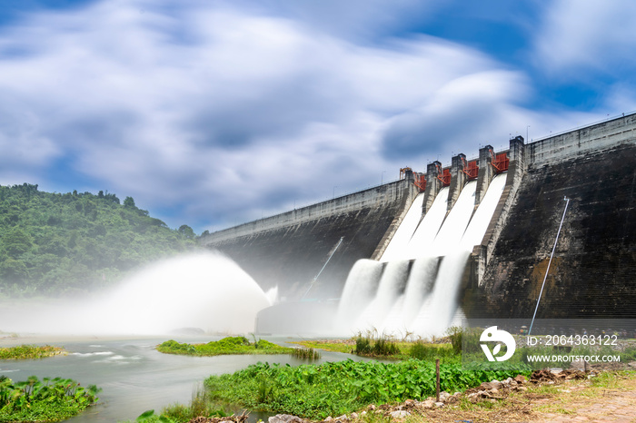 Long exposure photo of water release at spillway or overflows at big dam with blue sky and clouds (K