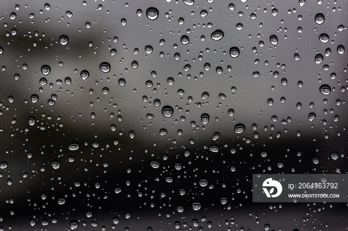 黑色潮湿背景/覆盖在窗户上的雨滴，秋季天气的概念，背景