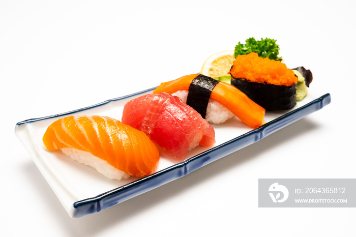 白色盘子上的寿司三文鱼、金枪鱼、寿司虾和芥末。选择性聚焦