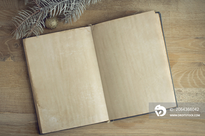 Christmas background - old blank open book with decorations around on vintage planked wood table fro