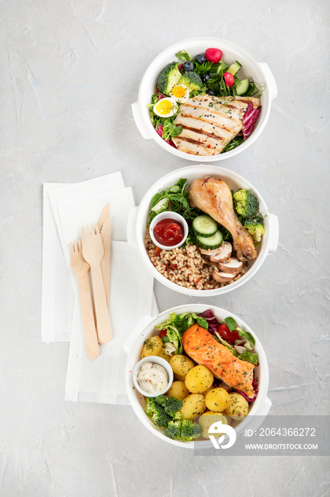 Healthy meal prep in lunch boxes on light background.