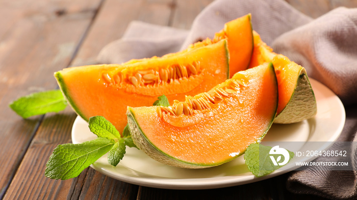 melon slice and mint leaf on plate