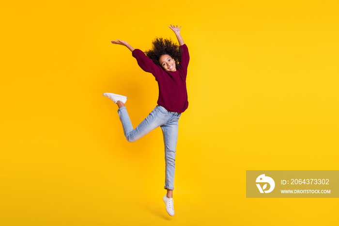 Full size photo of cheerful dark skin person jumping have fun wear sweater isolated on yellow color 