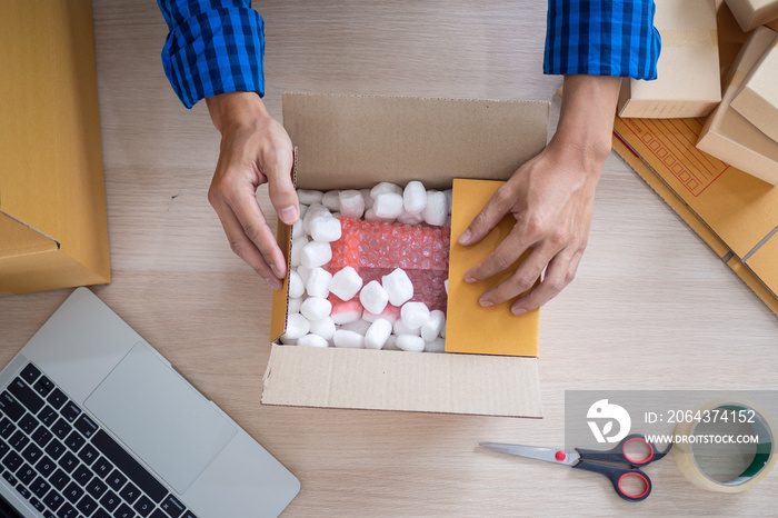 Online merchants packing items into paper boxes. In order to deliver parcels to customers. deliver t