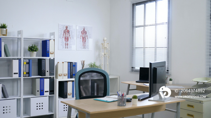 interior of the modern bright clinic office room with computers, human body anatomical chart on the 