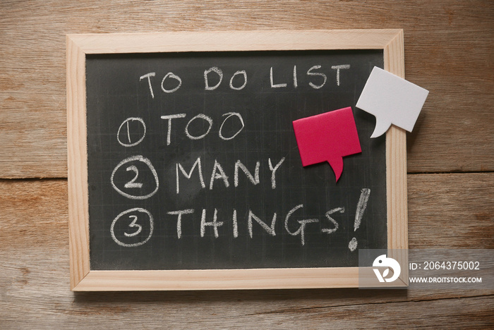 Top view of a blackboard with a chalk written with To do list : too many things! in numbers.