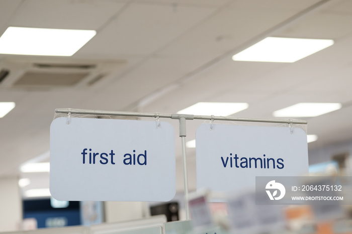 Shallow focus of First Aid and Vitamins location sign seen in a well-known retail pharmacy business.
