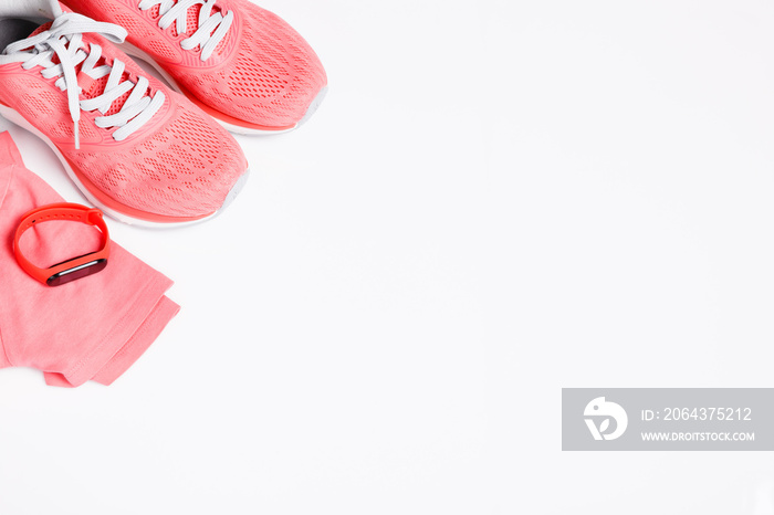 Fittnes sport composition with pink sneakers, smart bracelet on white background.