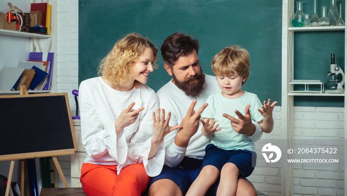 Family school. Funny little child with family having fun on blackboard background. School concept. K